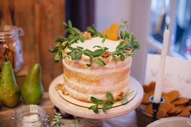 yeşil, bir tablo üzerinde duruyor süslenmiş beyaz düğün pastası