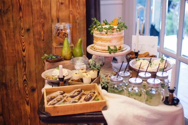 Söta bar med eclairs, saft, godis och vit tårta dekorera — Stockfoto