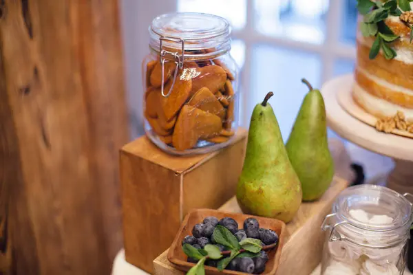 Godis-bar med blåbär, päron och grönska på träbricka. Swee — Stockfoto