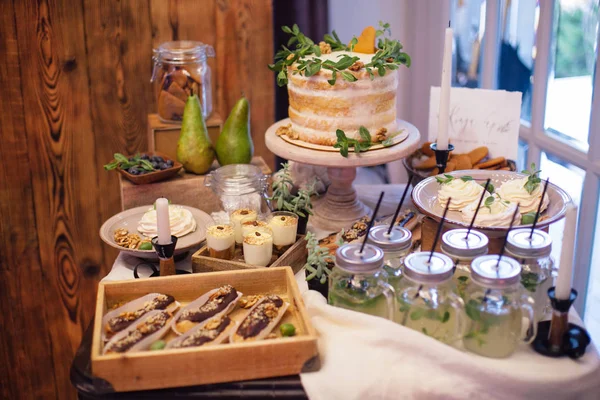 Söta bar med eclairs, saft, godis och vit tårta dekorera — Stockfoto