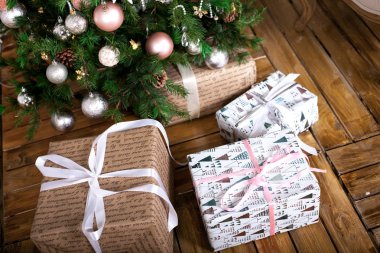 Noel ağacının altında paketlenmiş gi oluşan bir ahşap zemin üzerinde