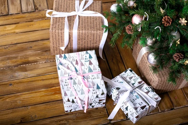 Noel ağacının altında paketlenmiş gi oluşan bir ahşap zemin üzerinde