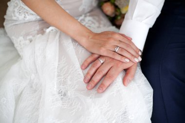 Gelin ve damadın nikah yüzükleri elleriyle. Yakın çekim