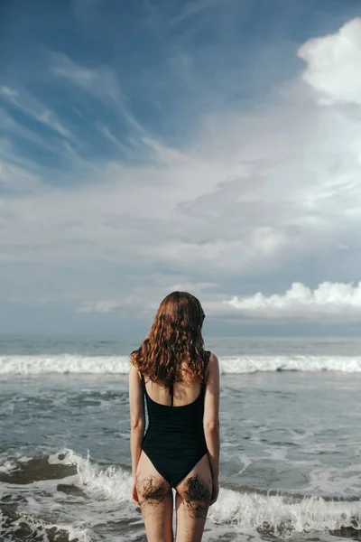 Mulher na praia vista traseira da bela mulher vestindo biquíni preto — Fotografia de Stock