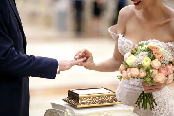 Noiva coloca um anel no dedo do noivo no cartório do casamento. Recém-casados trocando anéis — Fotografia de Stock