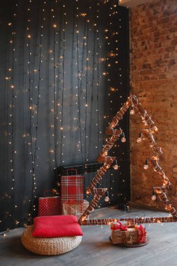 Alternatif ahşap Noel ağacı. El yapımı bir yılbaşı ağacı. Çiçekli bir ampul, siyah arka planda. Çatı katı. Boşluğu kopyala