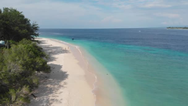 ターコイズブルーの澄んだ海の水と白い砂浜と熱帯の島の海岸線の緑とビーチの空中ビュー。インドネシアのジリ・メノ — ストック動画