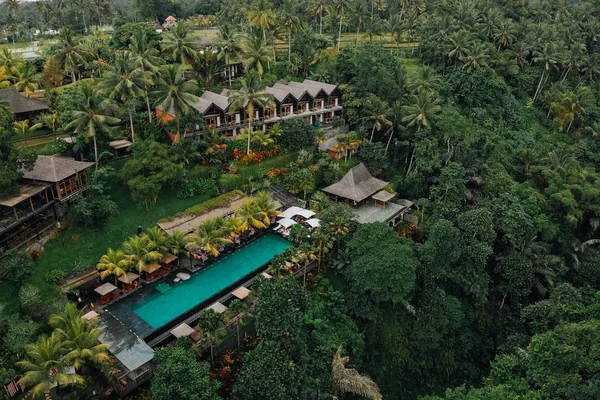 Luftaufnahme eines Luxushotels mit Strohdachvillen und Pools im tropischen Dschungel und Palmen. Luxuriöse Villa, Pavillon im Wald, Ubud, Bali — Stockfoto
