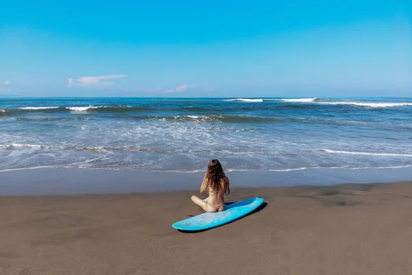 Beautiful sporty surfing woman in sexy bikini sit on longboard surf surfboard board on beach before surfing. Modern active sport lifestyle and summer vacation — Stock Photo, Image