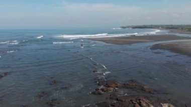 Top aerial view from flying drone above ocean landscape with big waves and rocks on black sand beach. Copy space for your advertising text message or promotional content