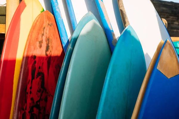 Set of different color surf boards in a stack by ocean.Bali.Indonesia. Surf boards on sandy beach for rent. Surf lessons on Weligama beach, Sri Lanka. — Stock Photo, Image