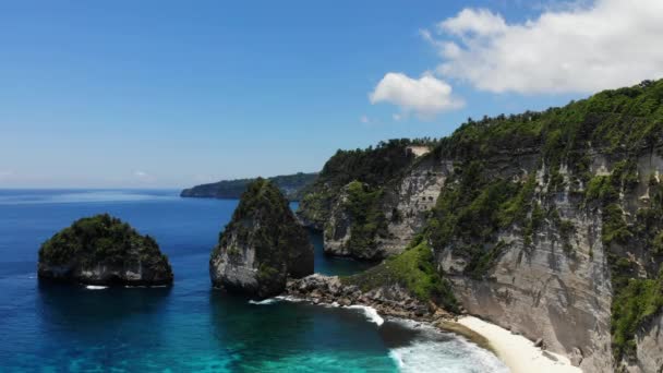 Pohled na tropickou pláž, mořské skály a tyrkysový oceán, modré nebe. Pláž Atuh, ostrov Nusa Penida, Bali, Indonésie. Tropické pozadí a pojetí cestování — Stock video