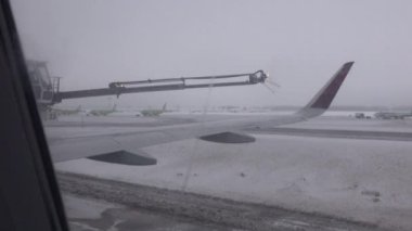 MOSCOW HAVAALANI RÜZİKA 'DA DAVA - HAZİRAN 2019: uçağın içerisindeki pencereden uçağın pervanesinin buzdan kimyasalları havaalanına püskürterek nasıl taşıdığını görmek.