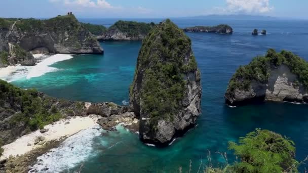 Vista aérea da costa tropical verde com água azul-turquesa e rochas da ilha de Nusa Penida, Praia Atuh, Bali — Vídeo de Stock