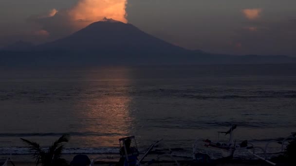 Blick auf den Vulkan Agung am Meeresstrand bei Sonnenaufgang von der Insel Nusa Penida, Bali, Indonesien. — Stockvideo