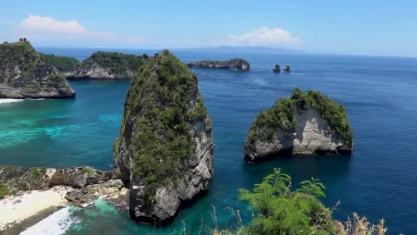 インドネシアのバリ島の近くにあるヌサペニダ島のオースビーチ。海と崖の空中ビュー。上から見たターコイズブルーの水の背景。空気からの夏の海. — ストック動画
