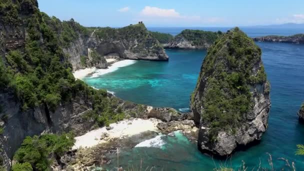 Veduta aerea drone di spiaggia tropicale, rocce marine, mare turchese e palme. Spiaggia di Atuh, Nusa Penida, Bali, Indonesia. Località di viaggio popolare e destinazione turistica — Video Stock