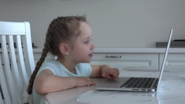 İnternetten bilgisayarını kullanan güzel bir kız internette yazarak gülümsüyor, karantina sırasındaki sosyal mesafe, kendini izole etme, online eğitim konsepti, evde eğitim veren biri. 