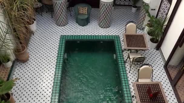 MARRAKESH, MARRUECOS - OCTUBRE 2019: Vista superior de la piscina en el patio en el lujoso riad marroquí con arquitectura de diseño árabe tradicional - interior de mosaico . — Vídeos de Stock