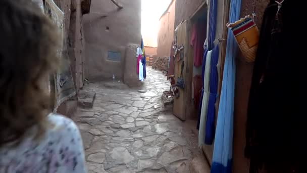 Unrecognizable woman walking through empty street of outdoor market stall in arabian ancient town Ait Benhaddou Morocco, slow motion — Stock Video