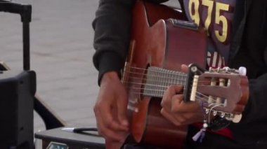 Dışarıda canlı performans sırasında siyah tenli Arap bir elin gitar çalması. Sokak sanatçısı 