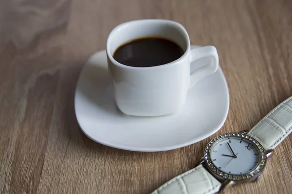 Sabahleyin bir fincan kahve. Beyaz kayışlı bilek saati. Sıcak bir ton. Yazıtlar için bir yer var. Günaydın..