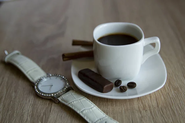 Sabahleyin bir fincan kahve. Beyaz kayışlı bilek saati. Sıcak bir ton. Yazıtlar için bir yer var. Günaydın..