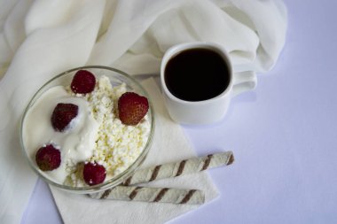 Bir fincan kahve, çilekli süzme peynir, beyaz arka planda kurabiyeler. Günaydın, Kahvaltı..