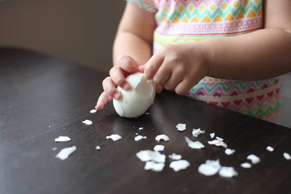baby cleans the egg hand