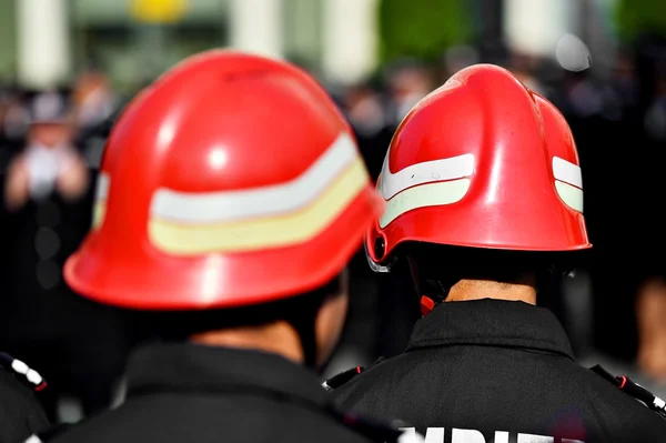 Capacetes de bombeiro vistos por trás durante o desfile — Fotografia de Stock