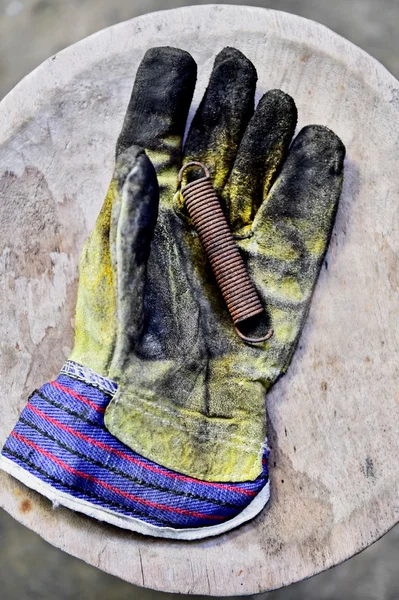 El guante del trabajador sostiene la llave del filtro de aceite — Foto de Stock