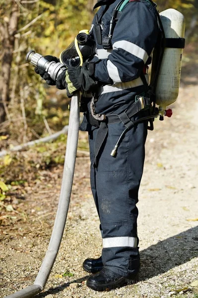 Strażak, trzymając przewód na wodę — Zdjęcie stockowe