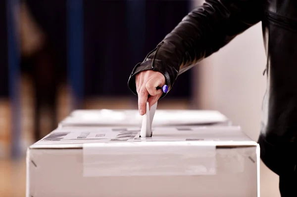 Hand casting a vote into the ballot box — Stock Photo, Image