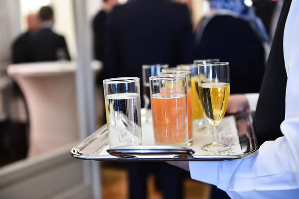 Garçom segurando uma bandeja com bebidas durante o coquetel — Fotografia de Stock