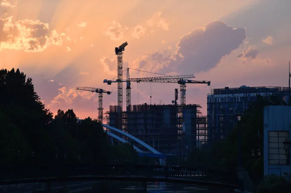 Construction cranes silhouetted — Stock Photo, Image