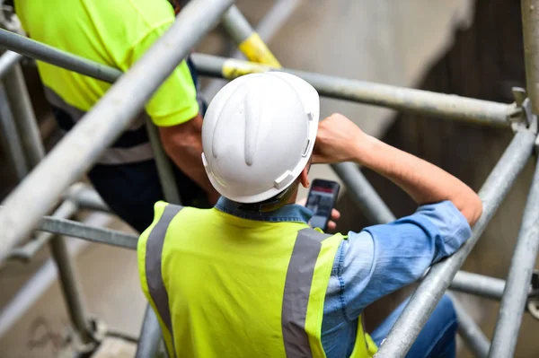 Workers inspecting construction works on a scaffold — Stock Photo, Image