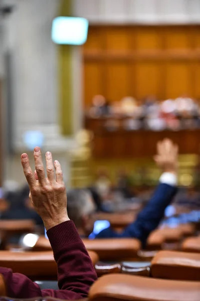 Ręką uniesioną do góry w powietrzu podczas procedury głosowania — Zdjęcie stockowe