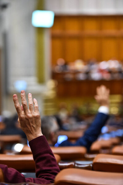 Рука, поднятая в воздухе во время процедуры голосования

