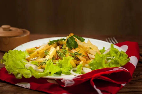 Smażone ziemniaki na białym talerzu z ziołami na podłoże drewniane — Zdjęcie stockowe
