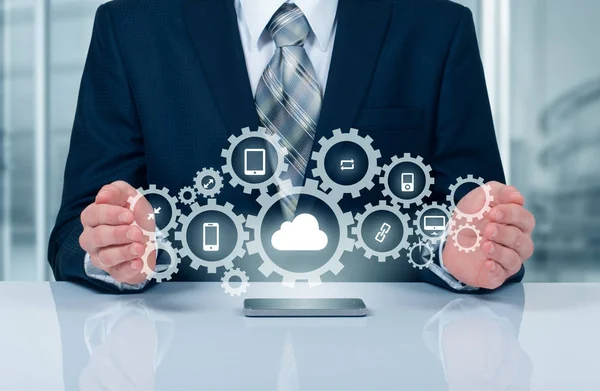 Бізнесмен тримає хмару, з'єднану з багатьма об'єктами на віртуальному екрані концепції про Інтернет речей — стокове фото