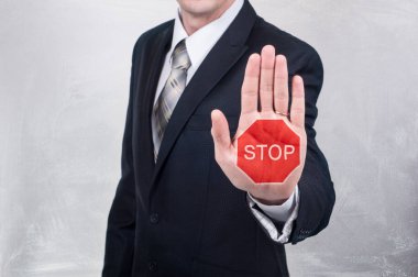 Dur işareti üzerinde el boyalı işadamı gösterir