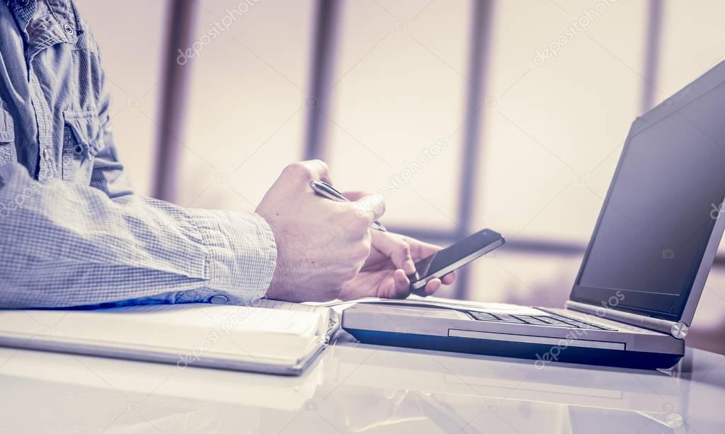Businessman working generic design laptop. Touching screen smartphone. Worldwide connection technology interface.