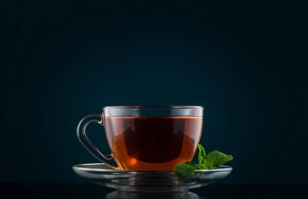 Taza de té con hojas de menta sobre un fondo oscuro —  Fotos de Stock