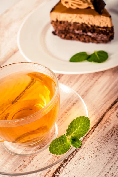 Pastel dulce con taza de té en la mesa de madera —  Fotos de Stock