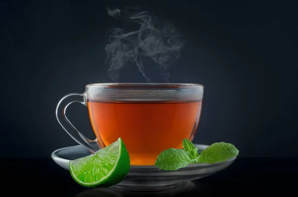 Taza de té con menta y lima sobre fondo negro — Foto de Stock