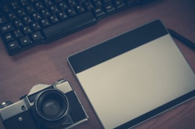 Ev ofis iç fotoğrafçı masa natürmort. Profesyonel fotoğraf medya çalışma donanımları, kamera gövdesi, lensler, monitör ve tablet