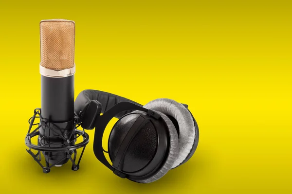 Casques et microphone à condensateur sur fond jaune — Photo