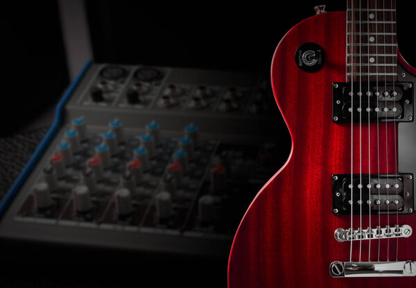 Red electric guitar and classic amplifier on a dark background.