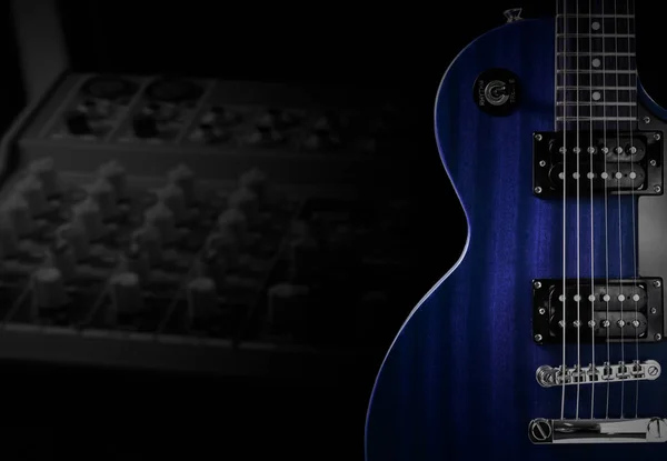 Blue electric guitar and classic amplifier on a dark background