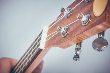 Gri bir arka plan üzerinde bir akustik gitar parçası.
